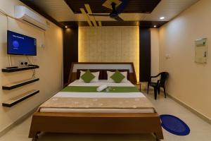 a bedroom with a bed and a tv in it at Guru Amrit Residency & Guru Kripa Guest house in Ayodhya