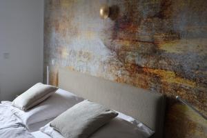 Ein Bett mit zwei Kissen neben einer rostigen Wand in der Unterkunft Ferienhaus Kleiner Muck in Glückstadt