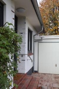 ein Haus mit einer weißen Tür und einer weißen Garage in der Unterkunft Ferienhaus Kleiner Muck in Glückstadt