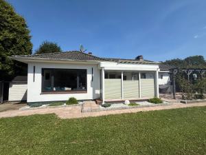 ein weißes Haus mit einem großen Fenster in einem Hof in der Unterkunft Ferienhaus Kleiner Muck in Glückstadt