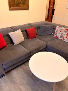 un divano marrone con cuscini e un tavolo bianco di Ferienwohnung Schöntal 1 a Ludwigswinkel