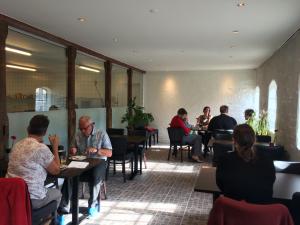 un grupo de personas sentadas en mesas en un restaurante en Kildegaarden Bed & Breakfast en Frørup