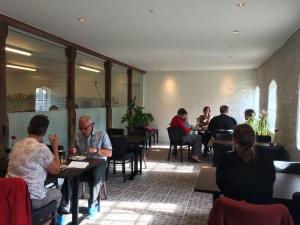 a group of people sitting at tables in a restaurant at Kildegaarden Bed & Breakfast in Frørup