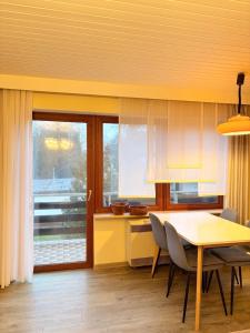 una cucina con tavolo, sedie e finestra di Ferienwohnung Schöntal 1 a Ludwigswinkel