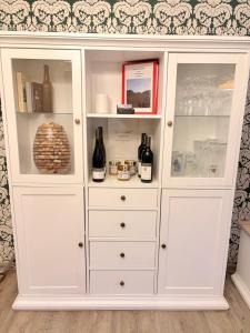 un armadietto bianco con bottiglie di vino di Ferienwohnung Schöntal 1 a Ludwigswinkel Altre 5 foto