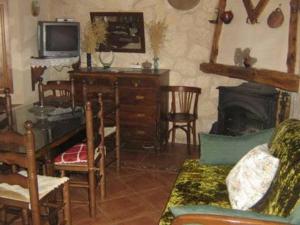 een woonkamer met een tv en een open haard bij Casa del Herrador I in Carrascal del Río