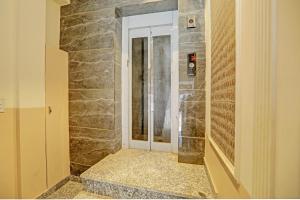 een inloopdouche met een glazen deur bij Hotel O Krishna Inn in Ghaziabad
