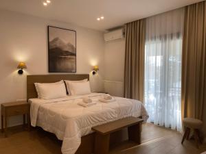 カト・ルートラキにあるLithosの大きなベッドとタオル2枚のある寝室