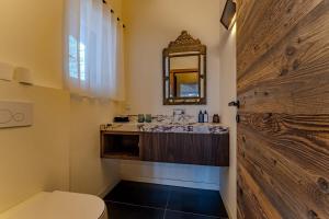 een badkamer met een wastafel, een toilet en een spiegel bij Luxurious Penthouse Lumina - Fire place, Pool and Spa in Val Thorens +49 foto's