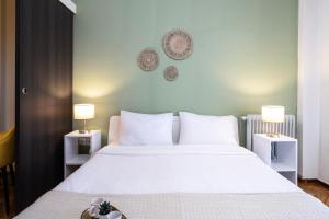 una camera da letto con un grande letto bianco con due lampade di Houseloft Bianca Vision a Salonicco