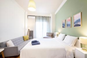 una camera da letto con un grande letto bianco e un divano di Houseloft Bianca Vision a Salonicco Altre 44 foto