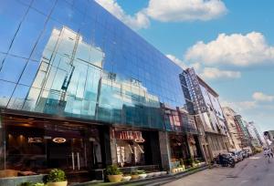 a building with glass windows on a city street at Hotel East End Delhi Airport in New Delhi