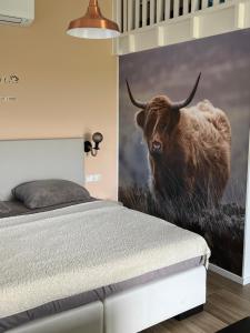 a bedroom with a painting of a bull on the wall at B&B de Landstreek in Hulten