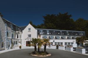 a large white building with palm trees in front of it at Fermain Valley Hotel in St. Peter Port
