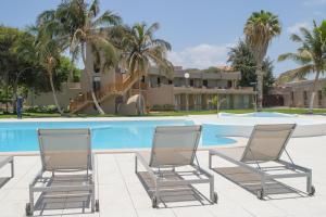 two chairs sitting in front of a swimming pool at Oasis Praiamar in Praia
