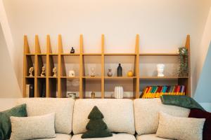 a living room with a couch and a shelf with vases at The Sky Hill - luxury chalet in Kupres