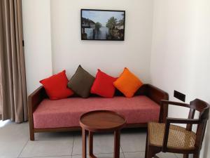 a couch with colorful pillows in a room at Creek Harbour Fort Kochi in Fort Kochi
