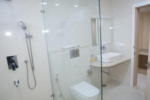 a bathroom with a shower and a toilet and a sink at Avadh Hotel & Banquets in Bareilly +40 photos