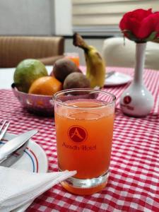 a glass of juice sitting on a table with fruit at Avadh Hotel & Banquets in Bareilly