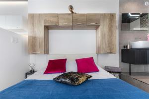 a bedroom with a bed with two red pillows at Village Naturiste R4N - Le Bocca Port Nature Coursive Luxe in Cap d'Agde