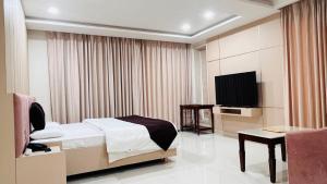 a bedroom with a bed and a flat screen tv at Avadh Hotel & Banquets in Bareilly