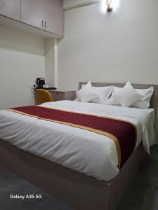 een slaapkamer met een groot bed met witte lakens bij AG Corporate Stay in Mahindra World City in Singapperumālkovil