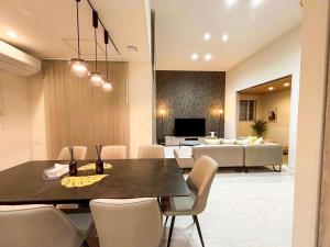 a dining room and living room with a table and chairs at Cozy Stay Pippu in Tōma