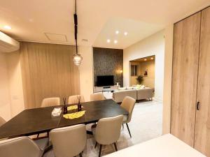 a dining room with a table and chairs and a living room at Cozy Stay Pippu in Tōma