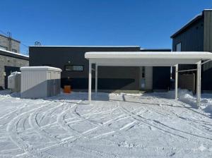 a snow covered parking lot in front of a building at Cozy Stay Pippu in Tōma