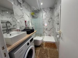 een badkamer met wastafel en wasmachine bij New studio apartment hotel Palais des Congrès 11 in Levallois-Perret