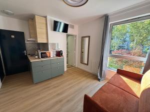 een woonkamer met een keuken en een raam bij New studio apartment hotel Palais des Congrès 11 in Levallois-Perret