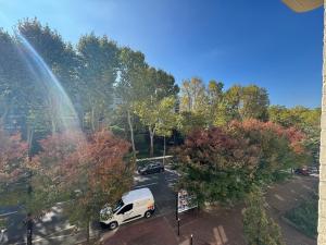 een witte bestelbus geparkeerd op een parkeerplaats met een regenboog bij New studio apartment hotel Palais des Congrès 11 in Levallois-Perret