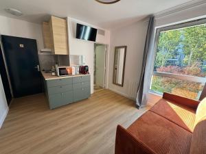 een woonkamer met een keuken en een groot raam bij New studio apartment hotel Palais des Congrès 11 in Levallois-Perret +3 foto's
