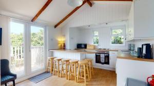 a kitchen with a counter and stools in it at C25 Weir View, Riviere Towans in Hayle