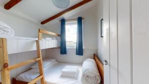 a small room with two bunk beds and a window at C25 Weir View, Riviere Towans in Hayle
