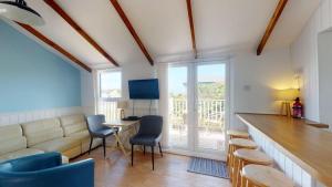 a living room with a couch and a table and chairs at C25 Weir View, Riviere Towans in Hayle