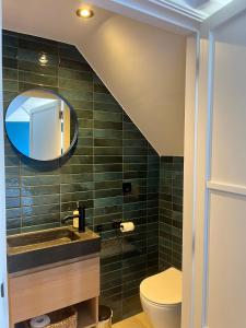 ein Badezimmer mit Waschbecken und Spiegel in der Unterkunft Groepsaccommodatie De Landerij in Scherpenzeel