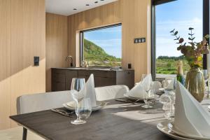 a dining room with a table with chairs and a window at NEW! High end cabin Lofoten 4 in Lyngværet