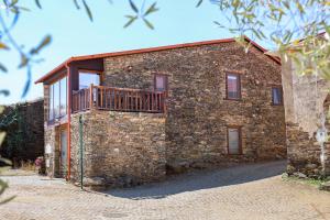 a stone house with a balcony on the side of it at PureAzibo in Macedo de Cavaleiros