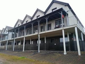 a building with a balcony with a person standing on the balcony at Apartament Ksawery parking w cenie podgrzewany basen in Rewal