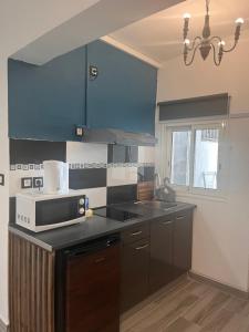 a kitchen with blue cabinets and a microwave at Chez Permal in Saint-Pierre