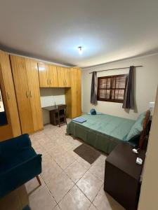 una camera da letto con un letto, una scrivania e un divano di Carneiro a Boituva