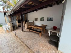 an outdoor patio with a wooden table and benches at Carneiro in Boituva