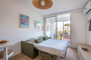 a living room with a bed and a balcony at Étoile de Mer * wifi * Parking * Clim * Central * in La Grande-Motte +42 photos