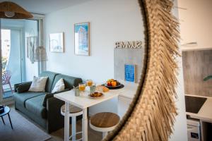 a living room with a couch and a table at Étoile de Mer * wifi * Parking * Clim * Central * in La Grande-Motte