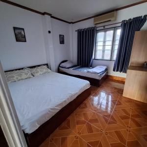 ein Schlafzimmer mit zwei Einzelbetten und einem Fenster in der Unterkunft Sichaluenkham vangvieng HOTEL in Vang Vieng