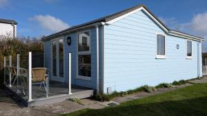 a tiny house with a deck in a yard at C25 Weir View, Riviere Towans in Hayle