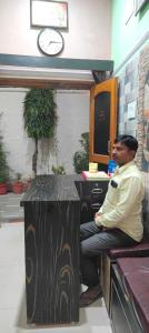 a man sitting on a counter in a bar at Shri Shiva Homestay by VM Stays in Varanasi