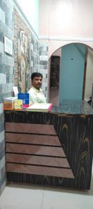a man sitting at a desk with a laptop at Shri Shiva Homestay by VM Stays in Varanasi