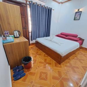 ein Schlafzimmer mit einem Bett und einem Holzboden in der Unterkunft Sichaluenkham vangvieng HOTEL in Vang Vieng